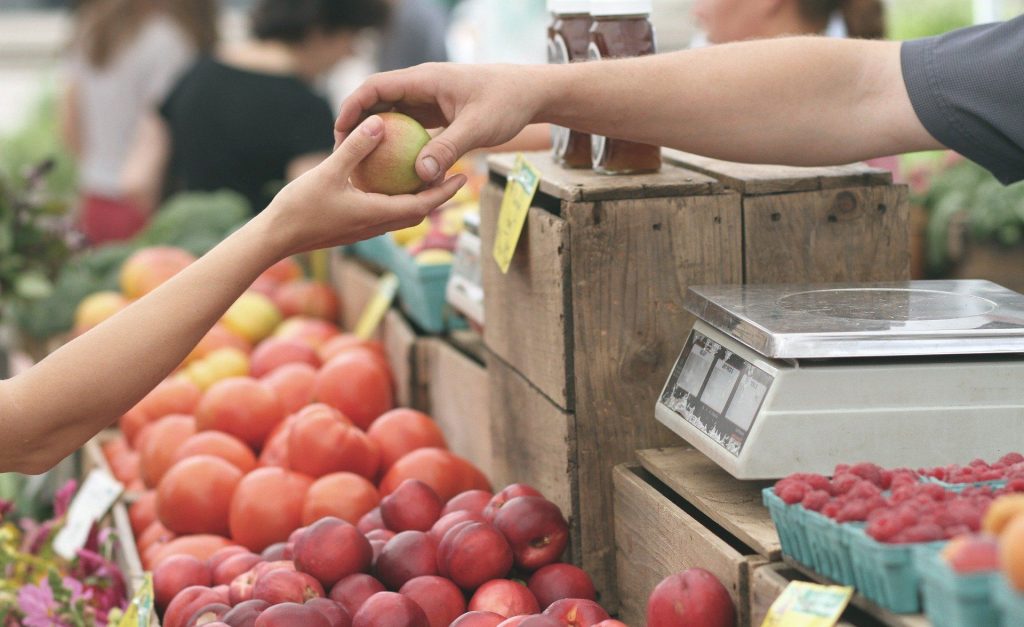 Transaction entre un client et un vendeur de fruits sur un marché