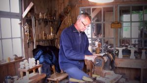 Un homme travaille le bois dans son atelier